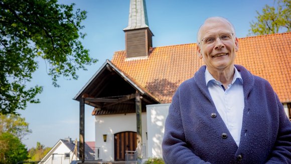 Ein Mann steht vor einer Kirche