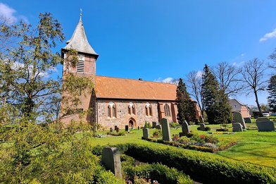 Außenansicht der Marienkirche Büchen-Dorf mit blauem Himmel und  grüner Rasenfläche vor der Kirche - Copyright: Ev.-Luth. Kirchengemeinde Büchen-Pötrau