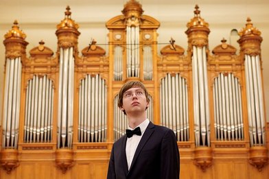 Schwarz gekleideter Herr vor einer Orgel - Copyright: Karina Fox 