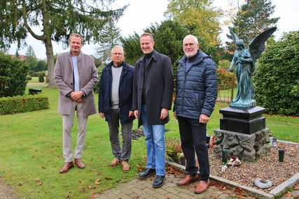 Vier Männre stehen zusammen auf einem Friedhof neben einer Engelsfigur. - Copyright: Thomas Biller