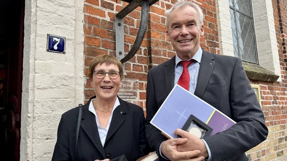 Zwei Personen stehen vor einer Kirche