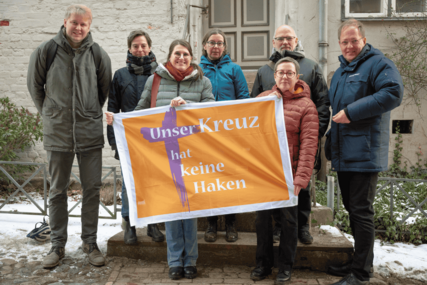 Personen halten Banner und schauen in die Kamera - Copyright: Oliver Beck