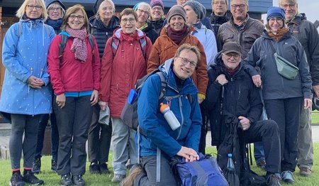 Eine Gruppe von Menschen in Wanderausrüstung lächelt in die Kamera.