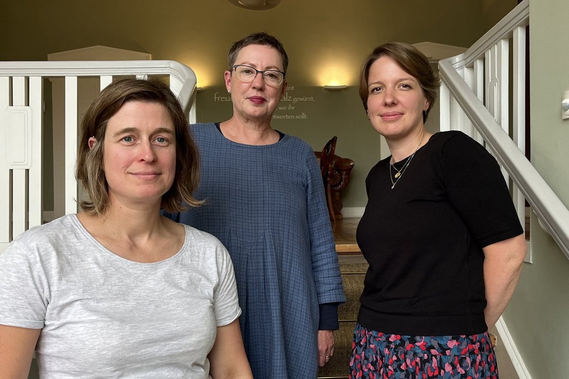 Drei Frauen stehen auf einer Treppe in einem Haus.