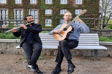 Auf einer Bank sitzen zwei musizierende Herren - Copyright: MusikErkennen