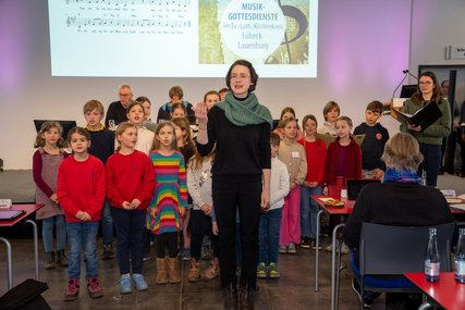 Singende Kinder und eine Chorleiterin  - Copyright: Oliver Beck 